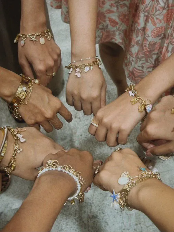 Eine Gruppe zeigt ihre selbst gestalteten Charm-Armbänder