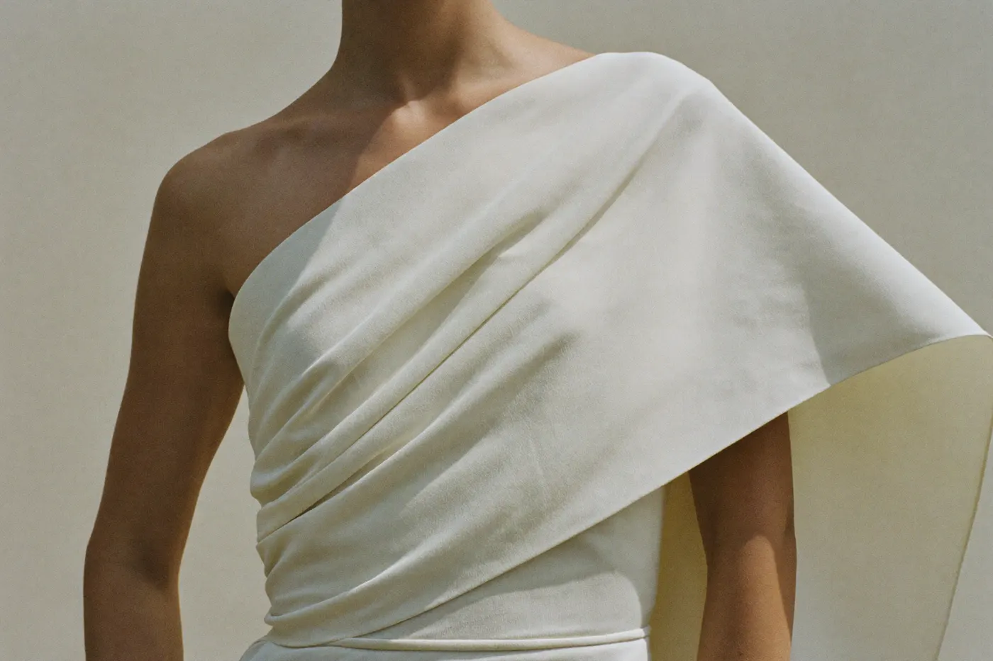 Diagonale Drapierung an der Taille eines asymmetrischen Brautkleids in Nahaufnahme