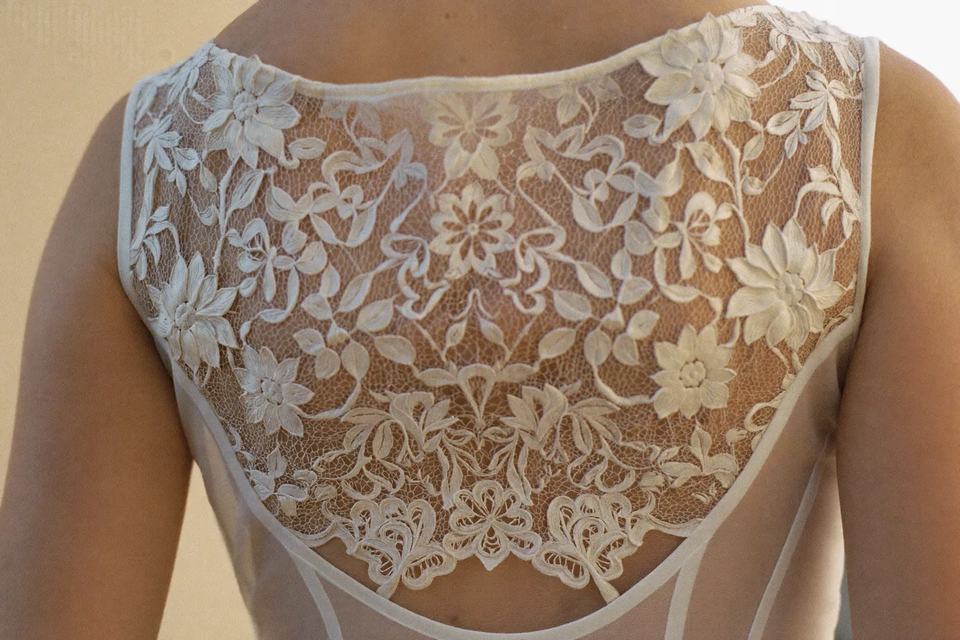 Detail eines Brautkleids in Blush: Ivory-Spitze über zartem Rosé-Unterkleid