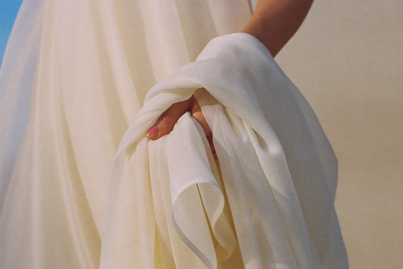 Hauchfeiner Chiffon-Stoff eines Brautkleids als Detailaufnahme in warmem Licht