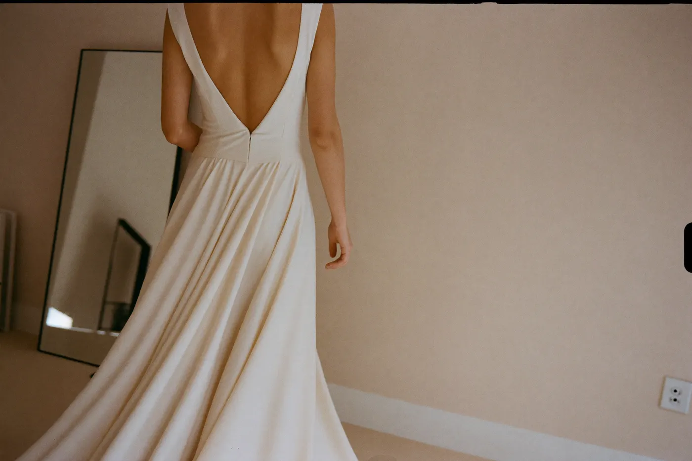 Braut in einem Designer-Brautkleid vor dem Spiegel