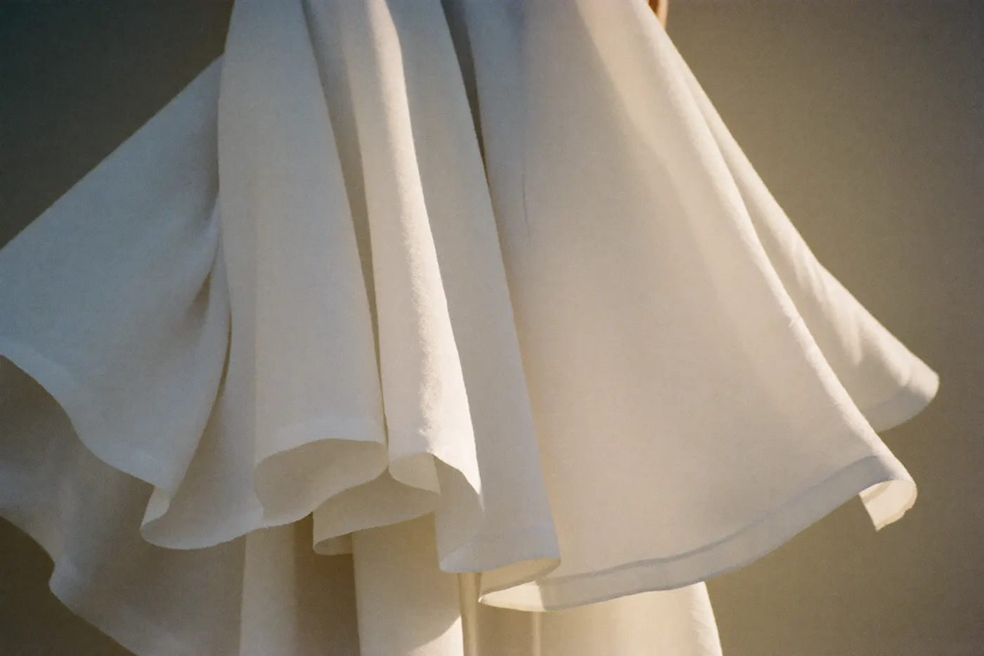 Leichte Stofflagen eines fließenden Brautkleids aus Chiffon und Crêpe in Nahaufnahme