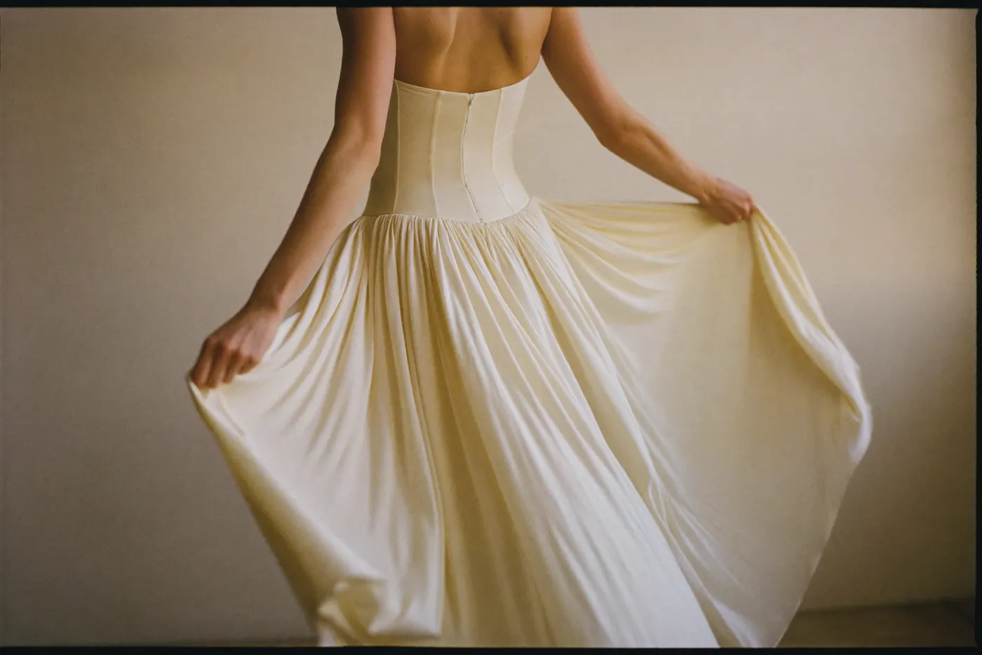 Fließendes Brautkleid bei der Anprobe, Braut von hinten dreht sich und der leichte Rock schwingt