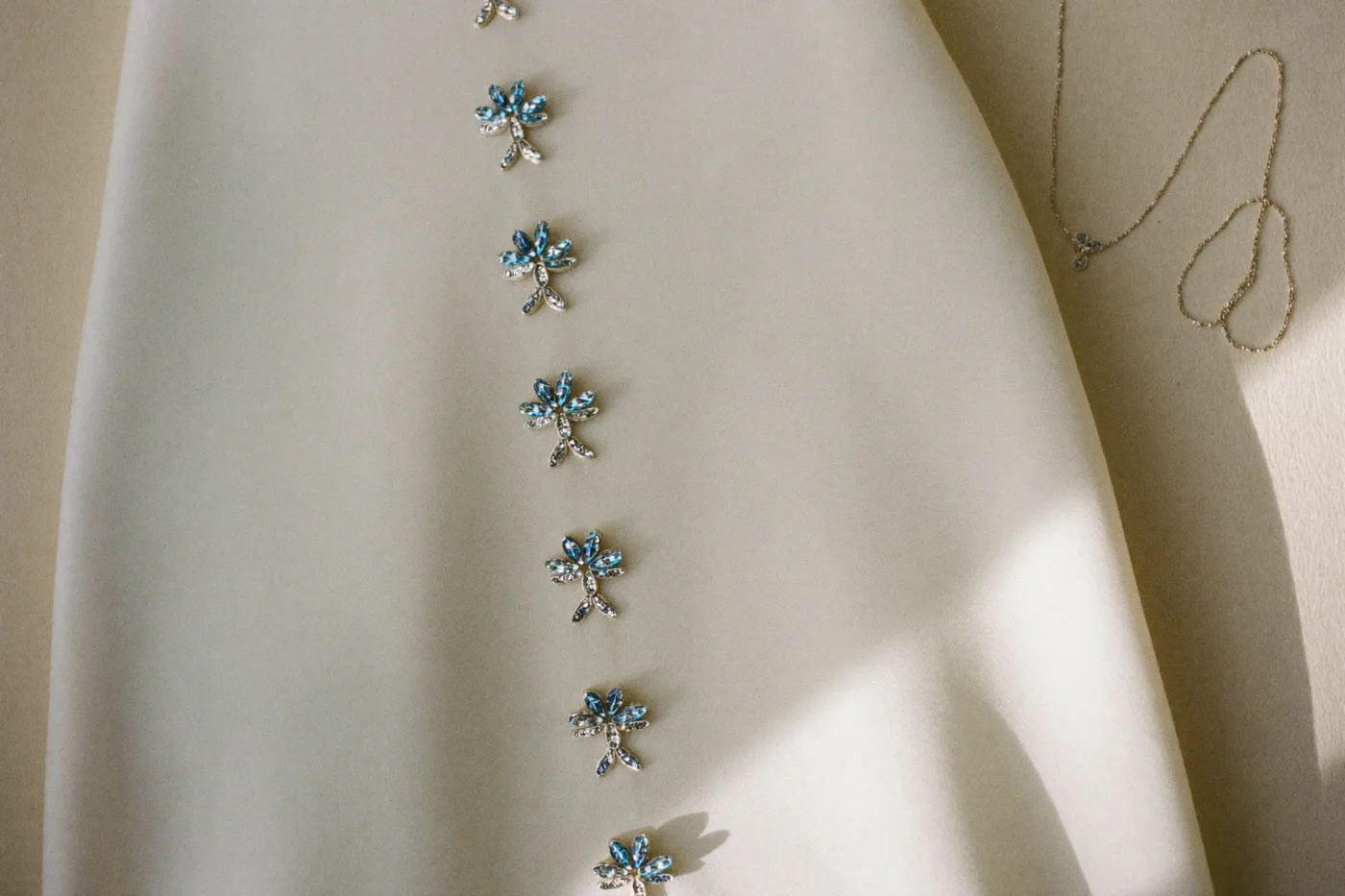 Glitzer Brautkleid mit Strass-Details und dezentem Schmuck als ruhiges Stillleben