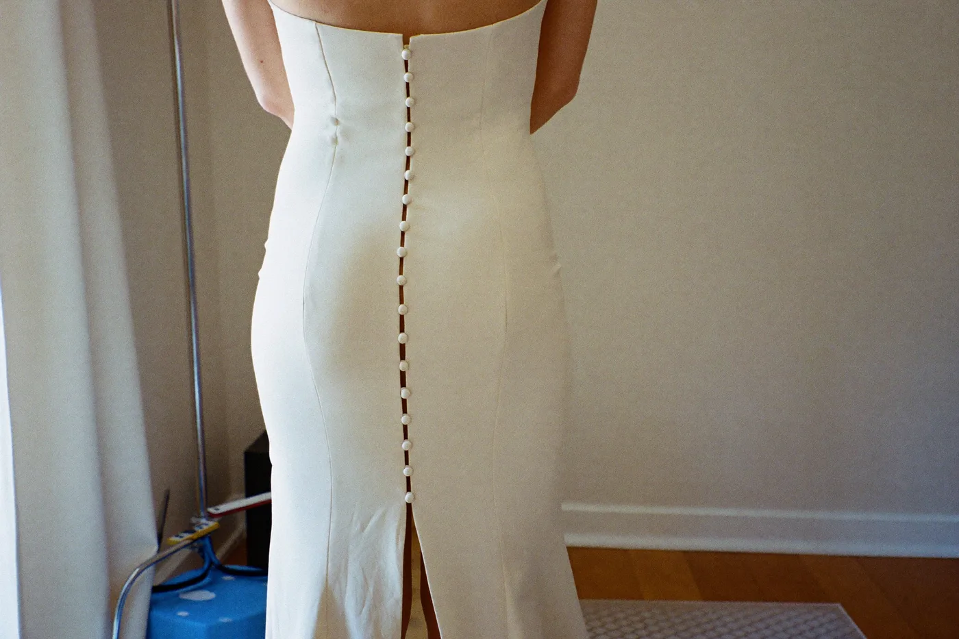 Braut von hinten im Luxus Brautkleid mit Knopfleiste bei einer privaten Anprobe