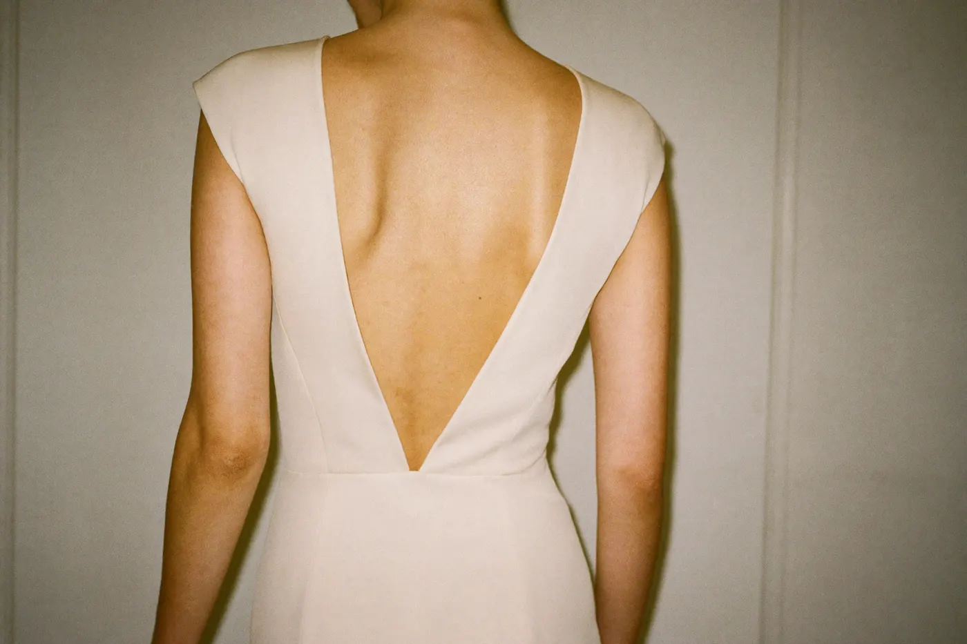 Minimalistisches Brautkleid aus Crêpe mit tiefem Rückenausschnitt, von hinten fotografiert