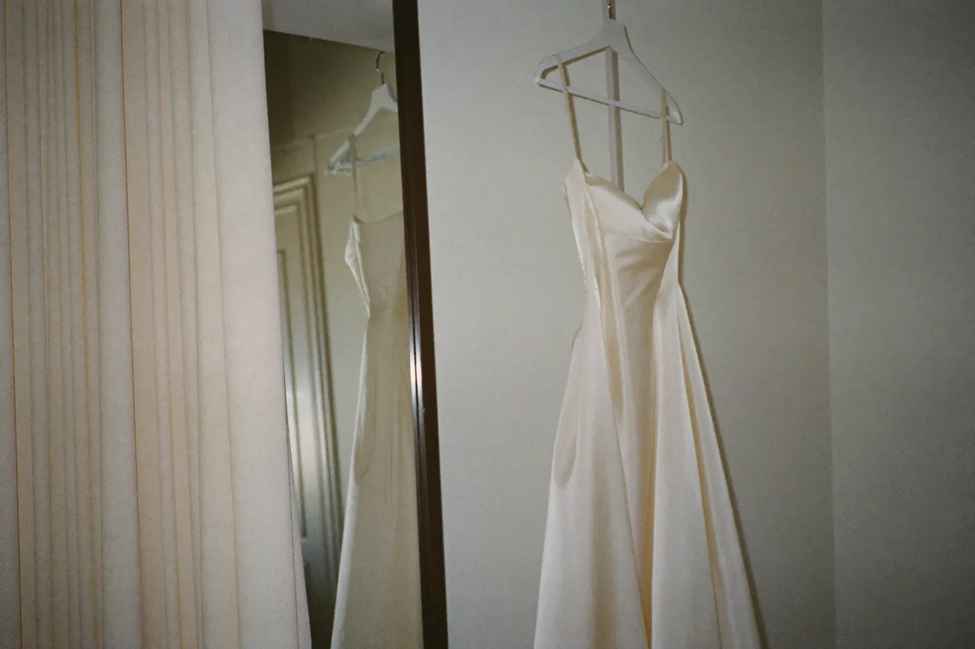 Minimalistisches Brautkleid auf einem Bügel im ruhigen Atelier bei der Anprobe-Vorbereitung