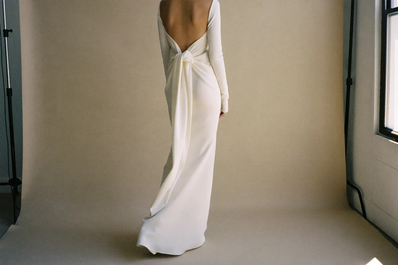 Minimalistisches Brautkleid aus Crêpe mit klarer Silhouette in weichem Tageslicht, ruhige editorial Aufnahme von hinten