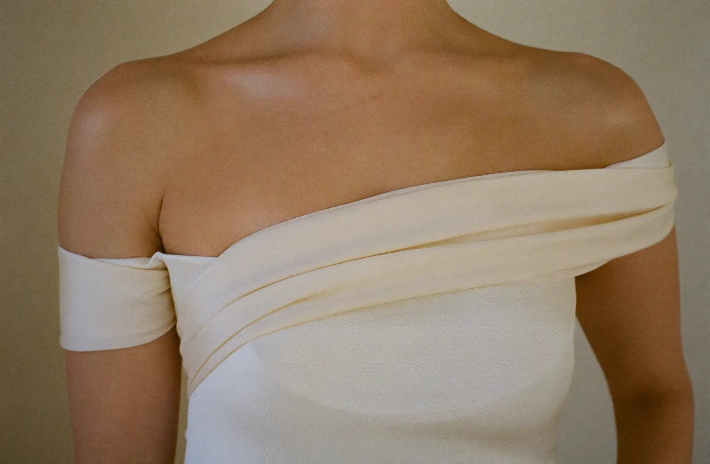 Detail eines Off-Shoulder Brautkleids mit verarbeitetem Oberteil und drapiertem Stoffband
