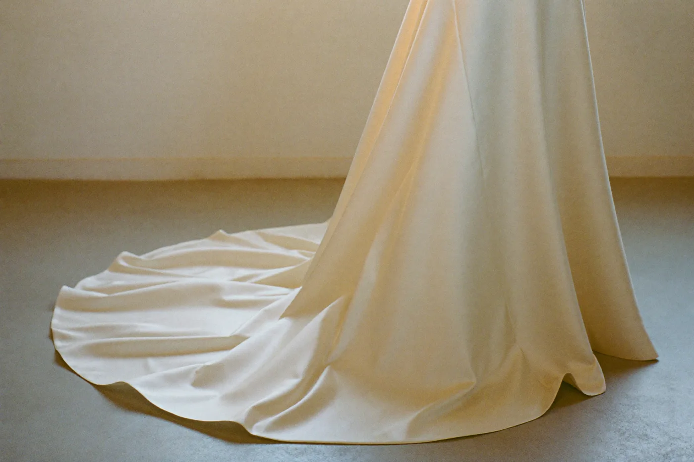 Schleppe eines Satin Brautkleids mit klaren Nähten im Atelier
