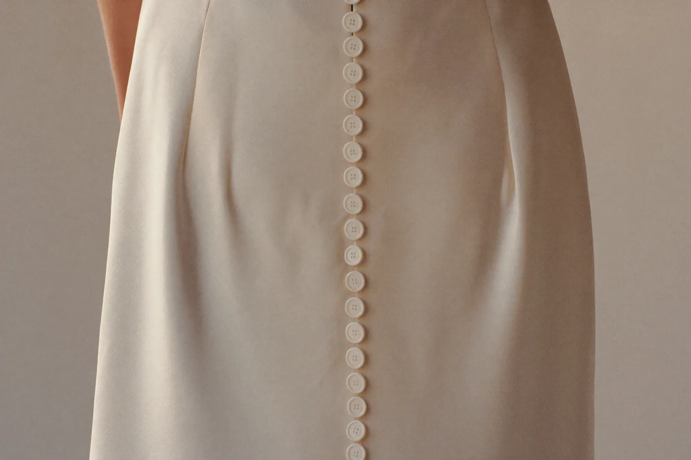 Detail eines schlichten Brautkleids mit Knopfleiste und mattem Stoff