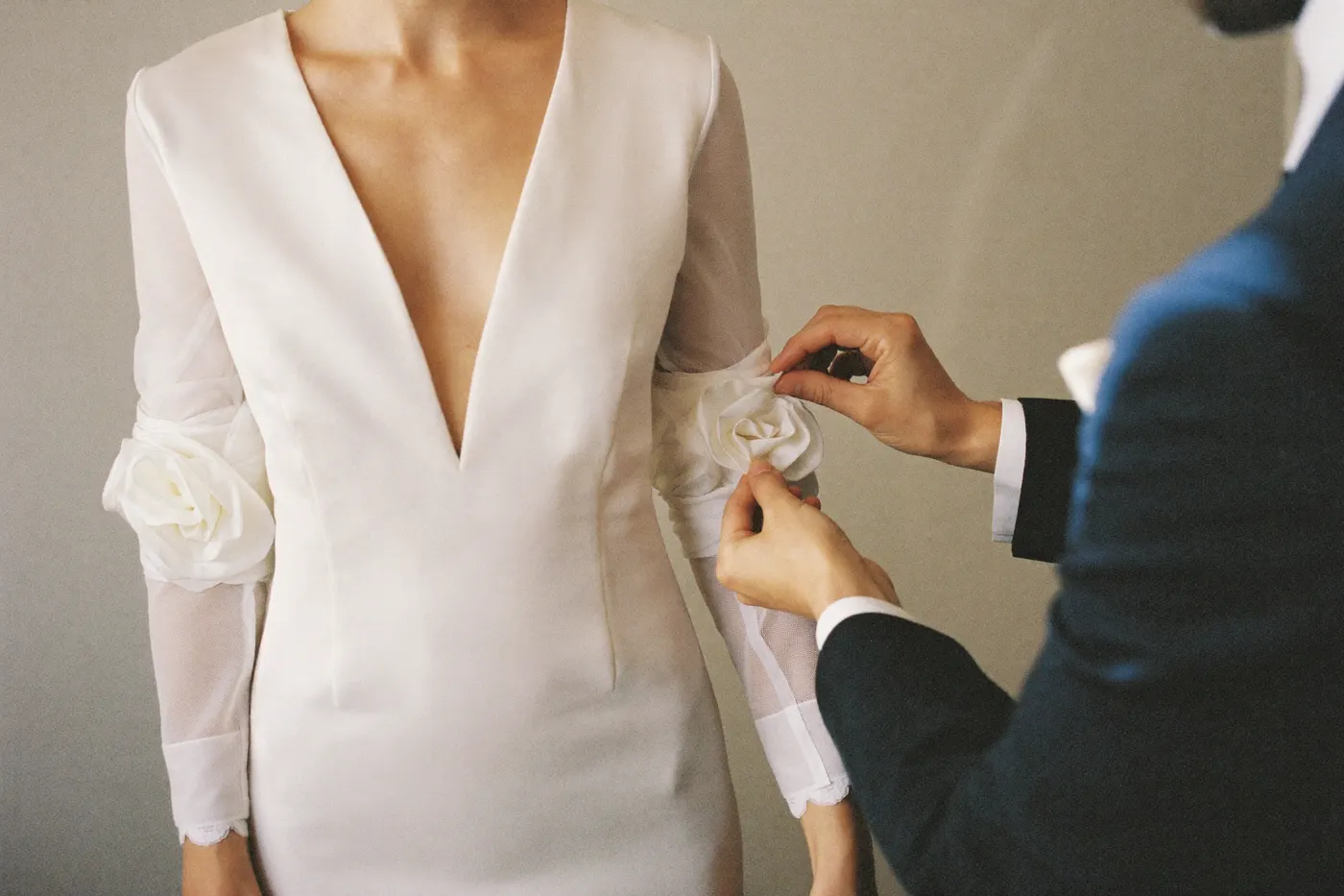 Anprobe-Szene: Spitzenärmel eines Brautkleids wird im Atelier angepasst