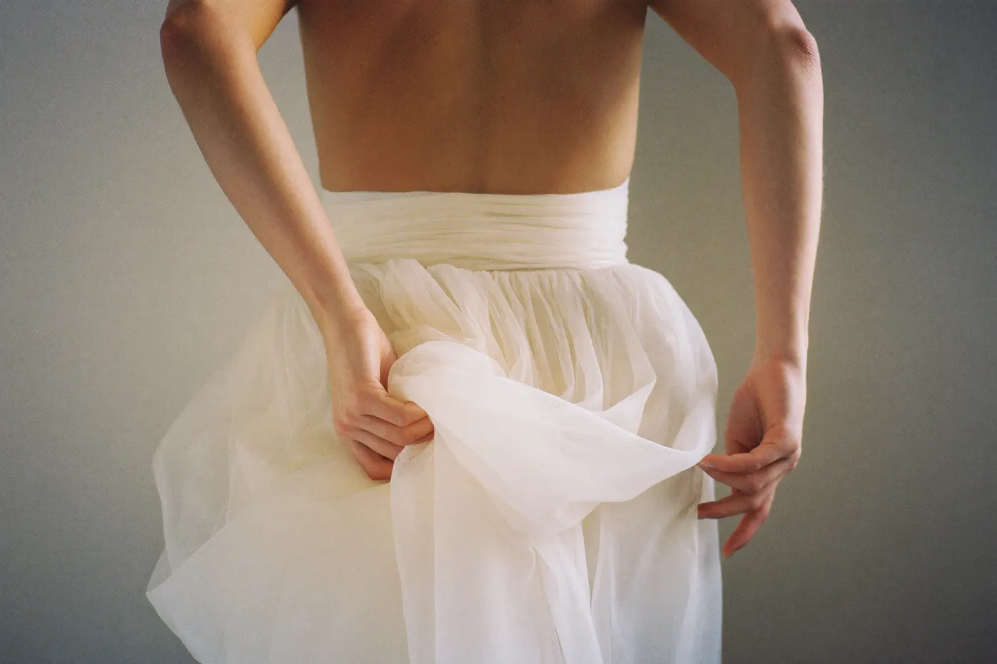 Braut von hinten im Tüll Brautkleid mit leicht angehobenem, luftigem Rock