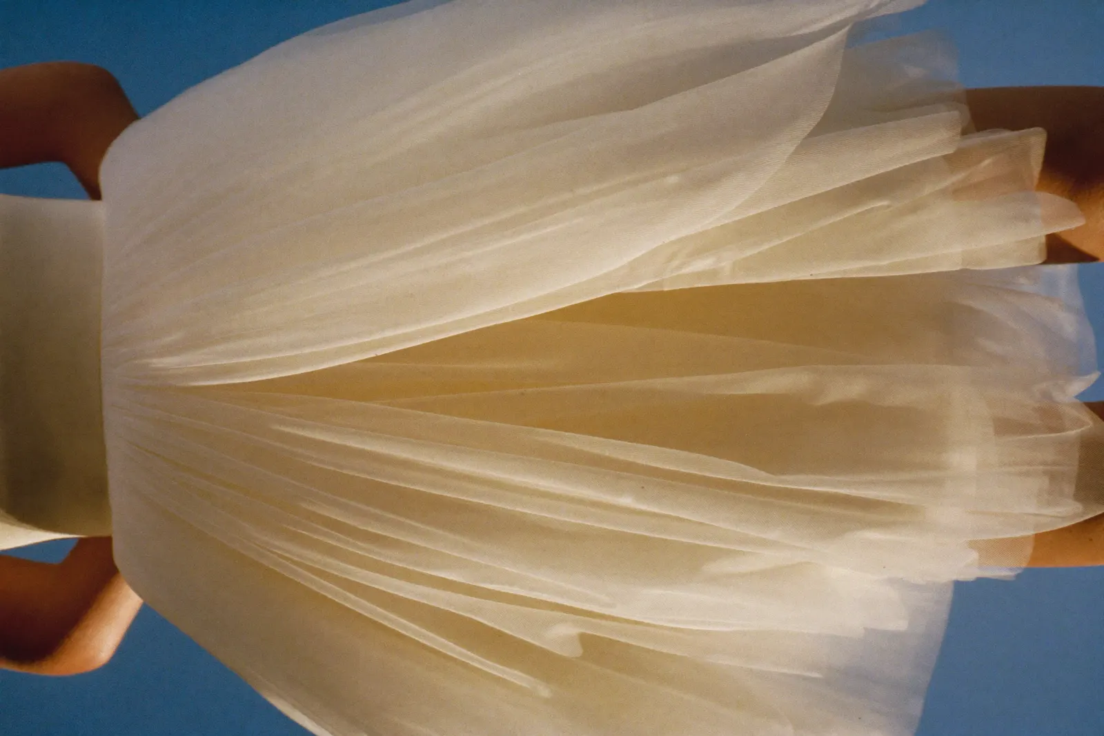 Tüll Brautkleid mit weich fallenden Lagen in warmem Tageslicht, Rock in sanfter Bewegung