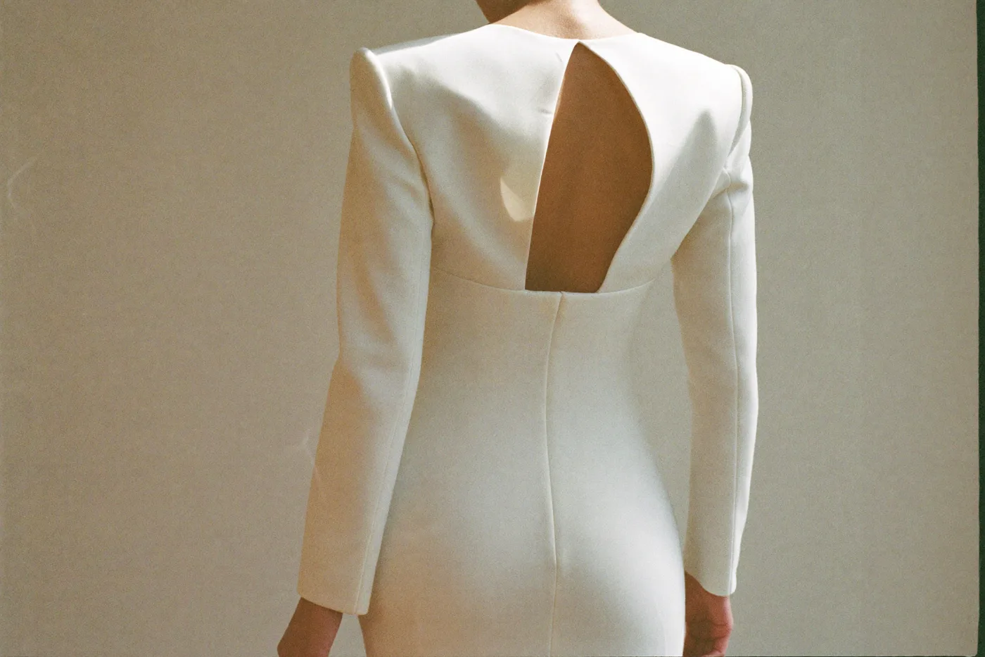 Braut von hinten im weißen Brautkleid aus klarem Reinweiß im weichen Tageslicht