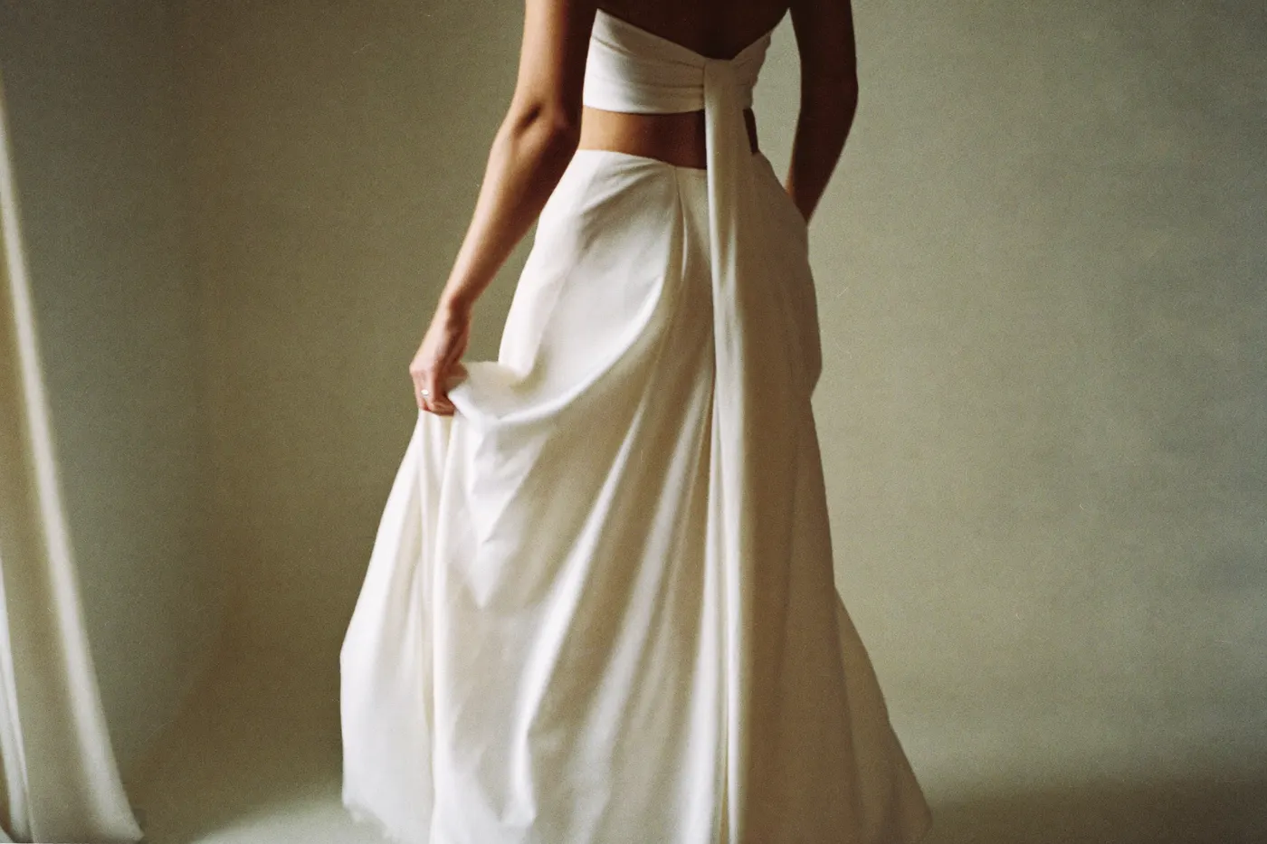 Braut im Zweiteiler-Brautkleid in ruhigem Licht