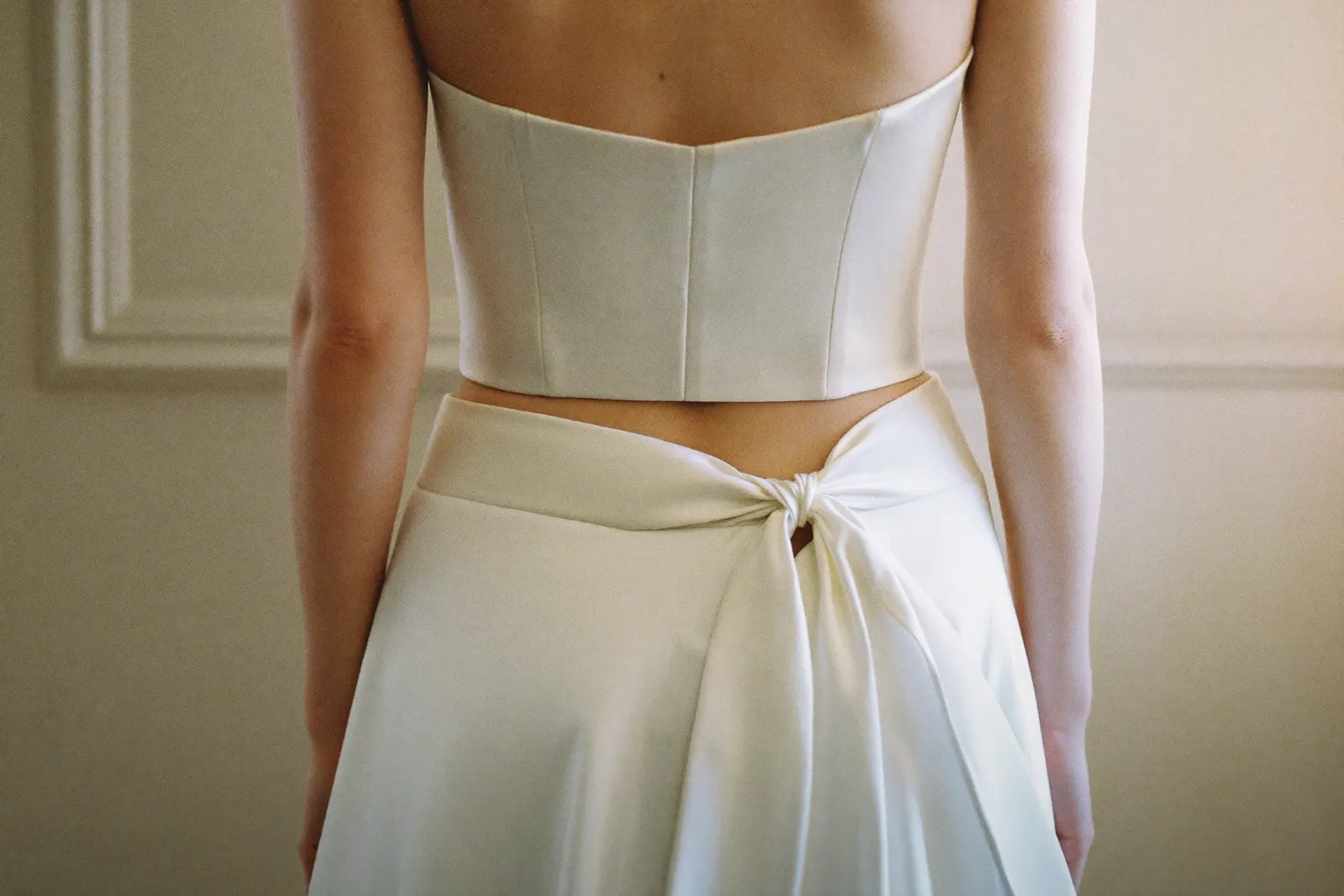 Braut im Zweiteiler-Brautkleid, ruhiges Tageslicht, faceless, Fokus auf Stoff und Schnitt